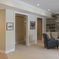 A Remodeled Basement Living Room With Fireplace, Lounge Area, And Plenty Of Natural Sunlight All Done By Basement Finishing Contractors At Foggy Ridge Interiors.