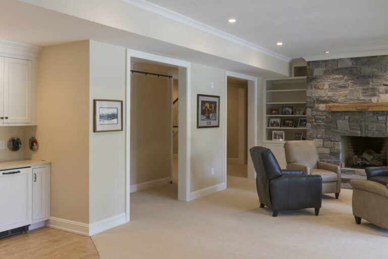 A Remodeled Basement Living Room With Fireplace, Lounge Area, And Plenty Of Natural Sunlight All Done By Basement Finishing Contractors At Foggy Ridge Interiors.