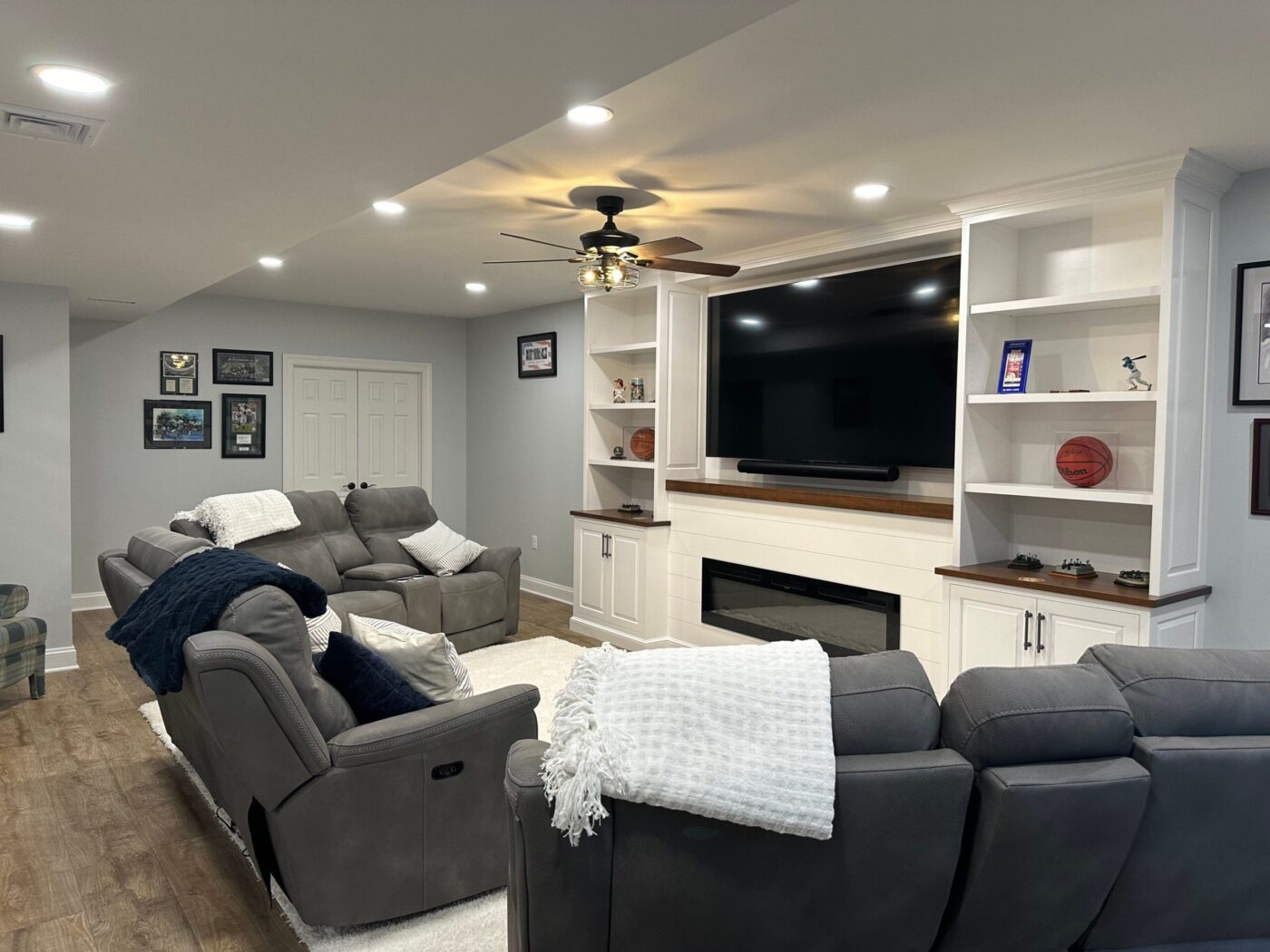 A Finished Basement Completed By A Home Remodeling Contractor In Downingtown Pa, With Shevles, Couches, And A Tv