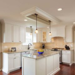 A Kitchen With Hardwood Flooring, White Cabinets, A Large Kitchen Island With A Granite Countertop, Coffered Ceiling With Recessed Lighting, Designed And Installed By Residential Contractors From Foggy Ridge Interiors.